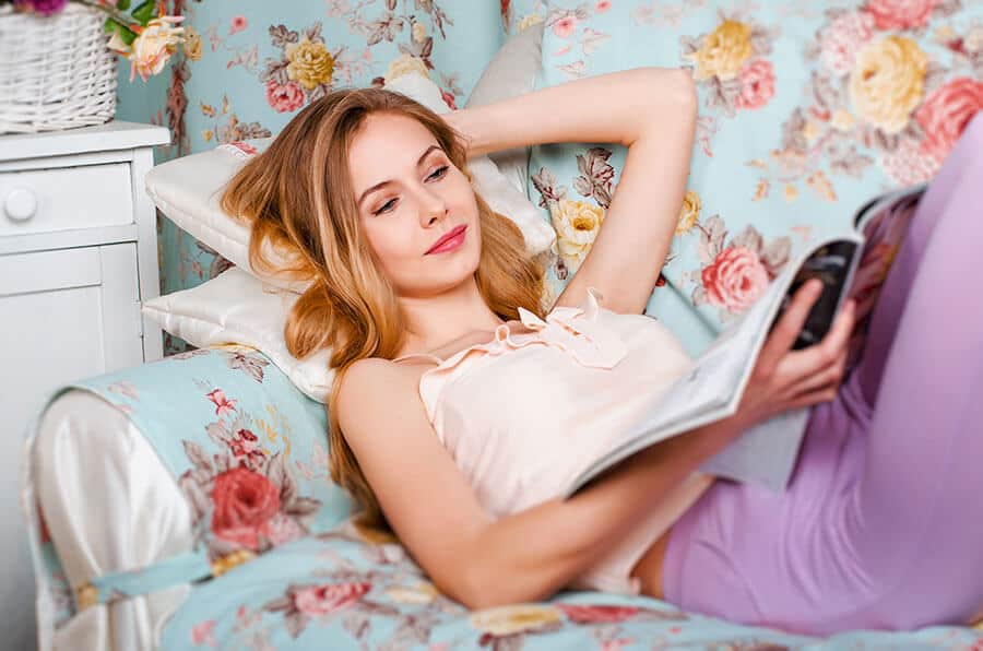 Girl lying on the couch reading a magazine