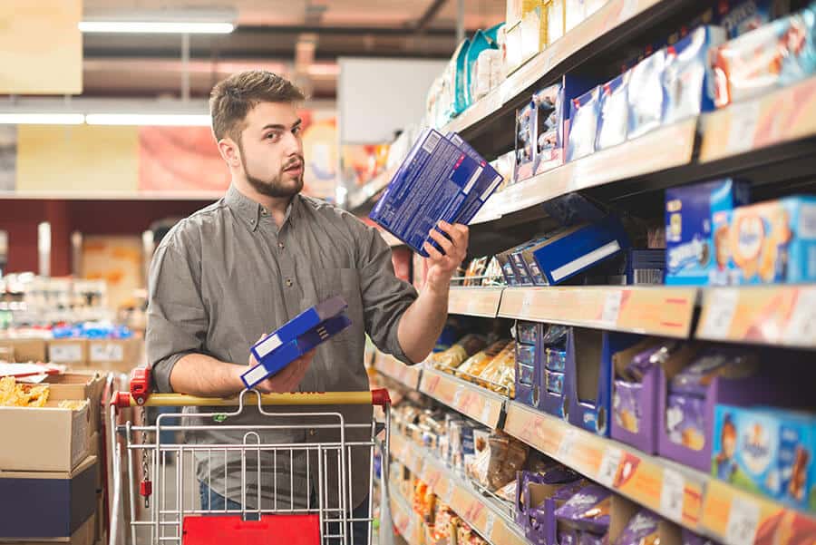 Man confused with the range of goods in supermarket