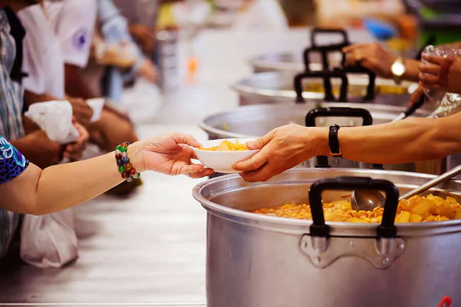 Volunteers serving food to the needed