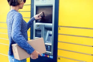 Woman using automated self service locker to deposit the parcel