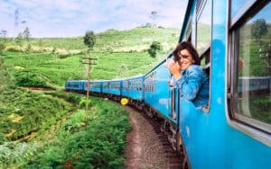 Happy smiling woman enjoying traveling by train on in Sri Lanka