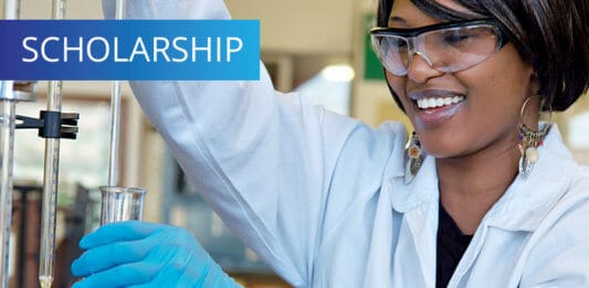 Happy smiling female researcher in chemical lab