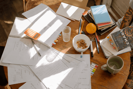 A desk with papers and food
