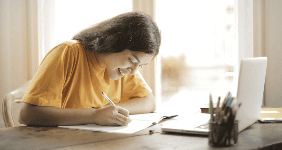 A child writing on a book.